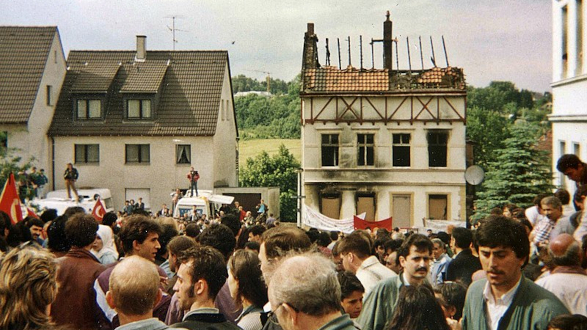 Solingen 1993: das abgebrannte Haus mit einer Menschenmenge davor