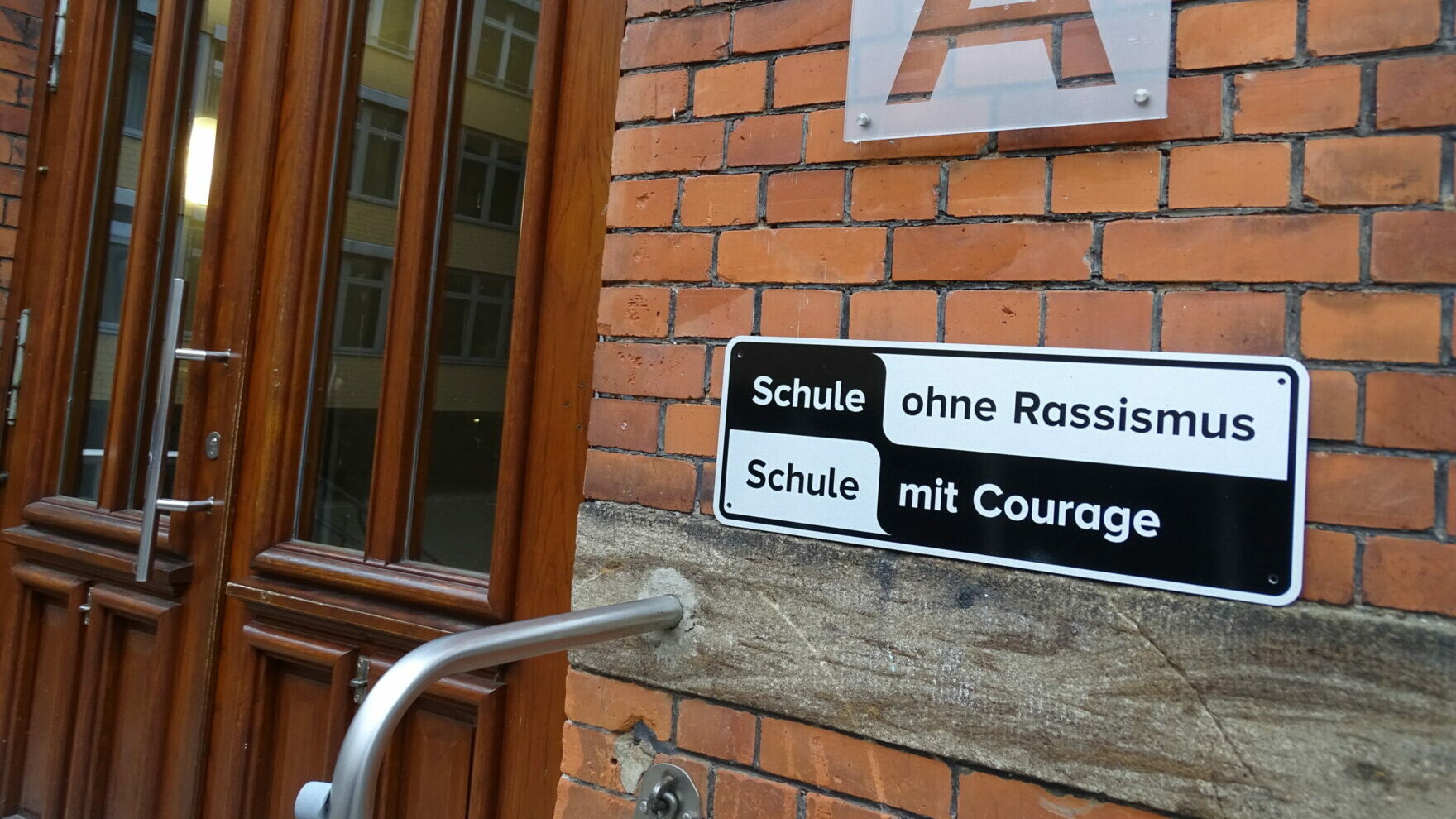 Schild Schule ohne Rassismus - Schule mit Courage an einem Schulgebäude