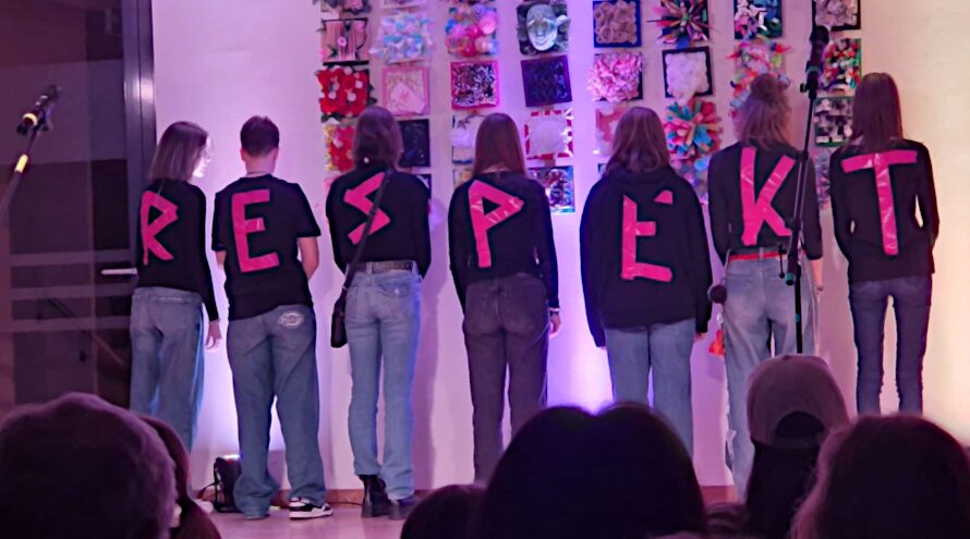 Schülergruppe auf der Bühne. Sie haben den Rpcken zugedreht, auf jedem ein buchstabe. Zusammen ergibt es: RESPEKT